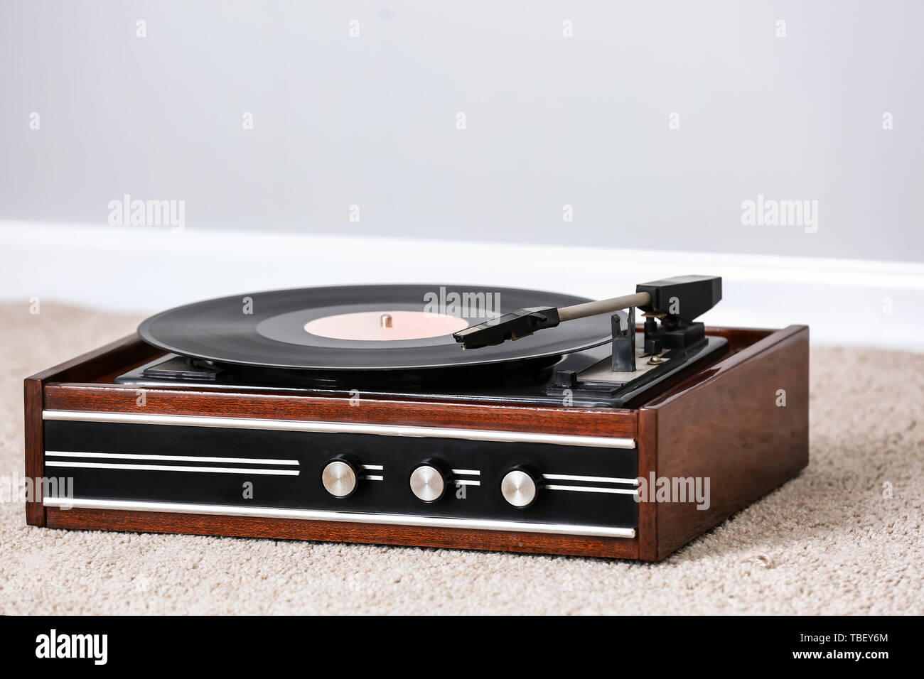 Record player with vinyl disc on floor in room Stock Photo - Alamy