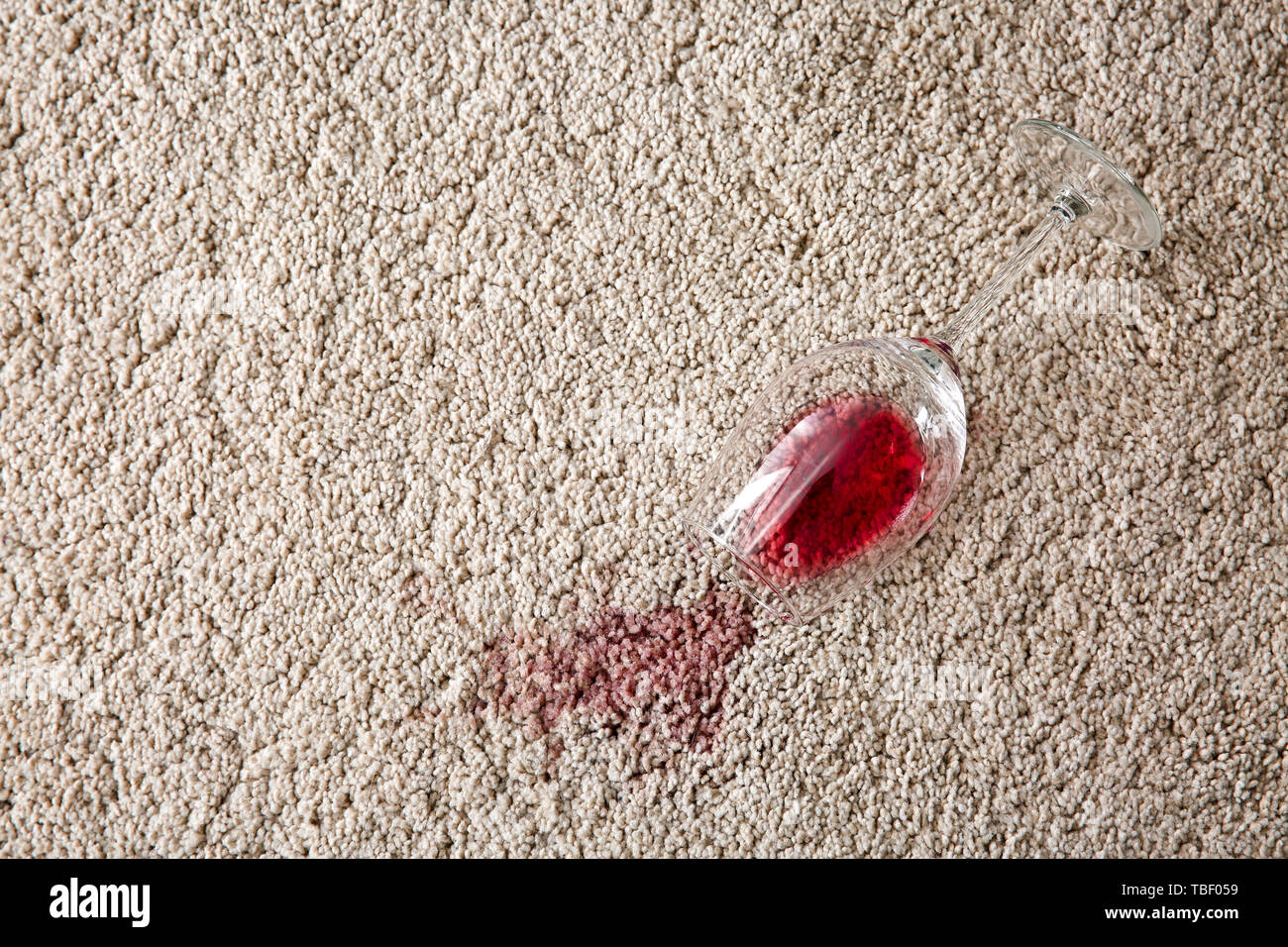 Glass of wine spilled on carpet Stock Photo Alamy