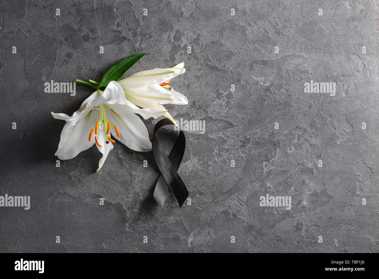 Black funeral ribbon and flowers on grey background Stock Photo - Alamy