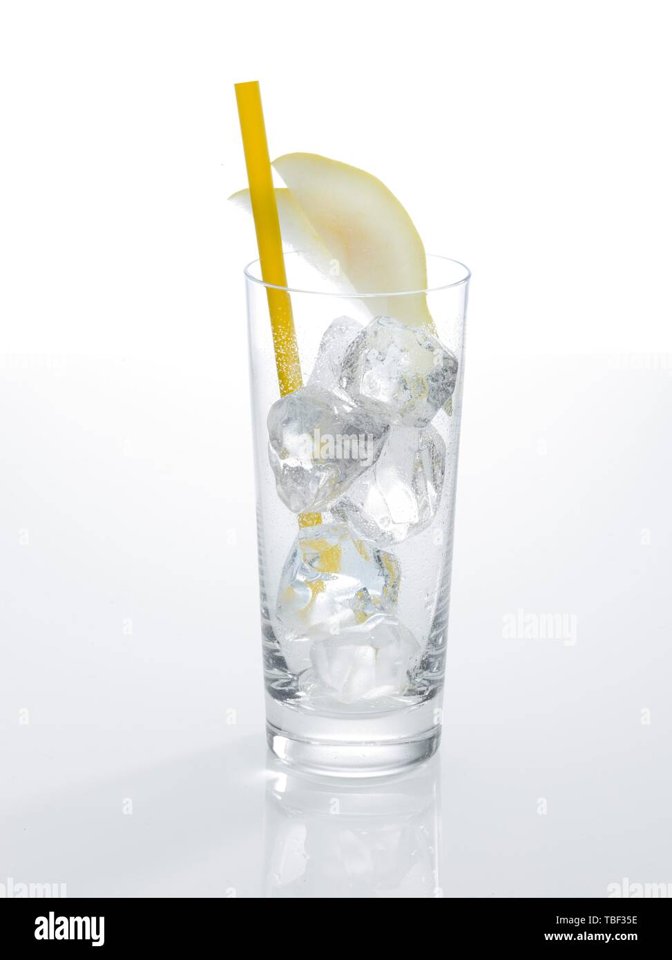 Glass prepared for cocktails, decorated with pear slice cubes, drinking