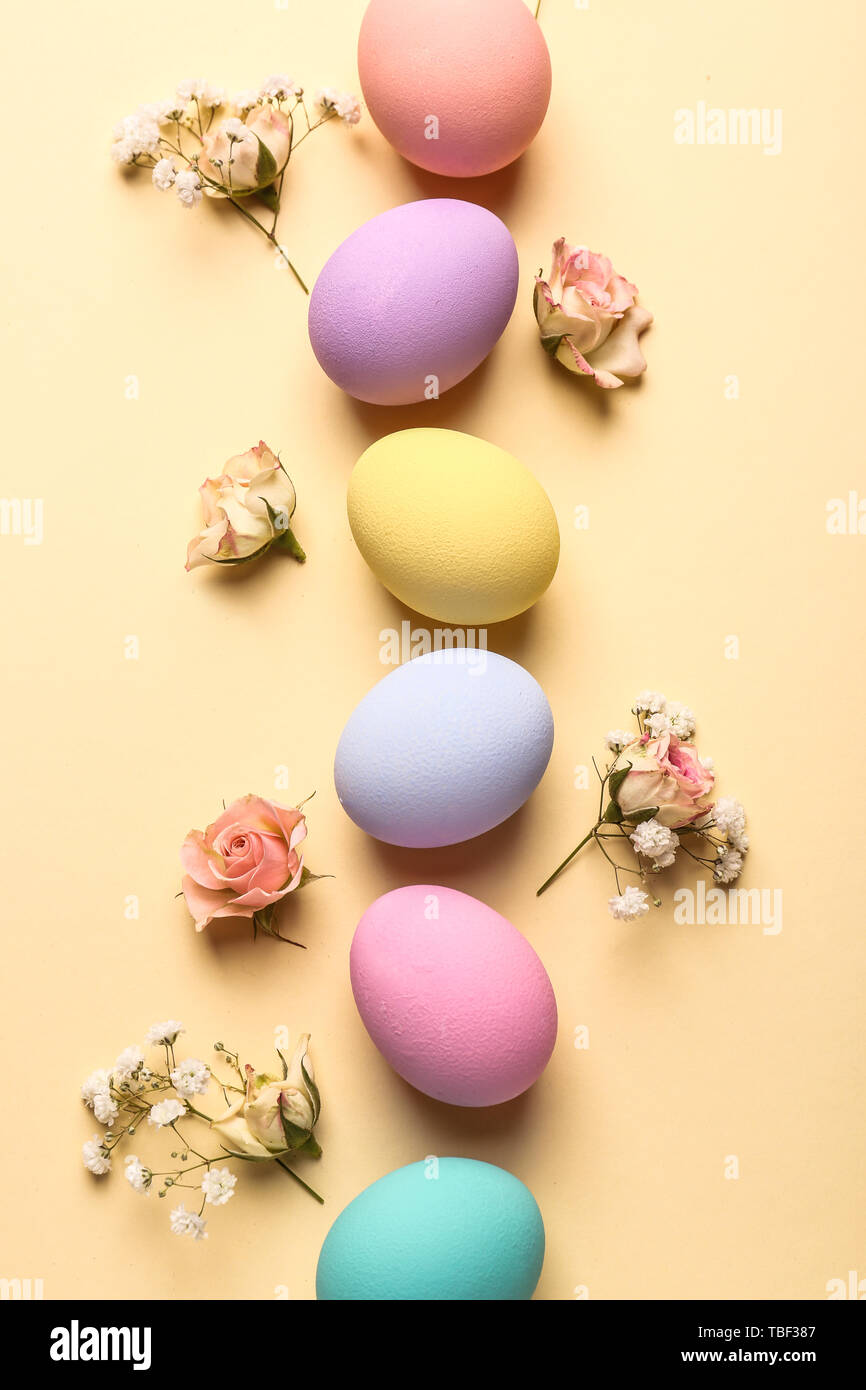 Easter eggs with flowers on color background Stock Photo