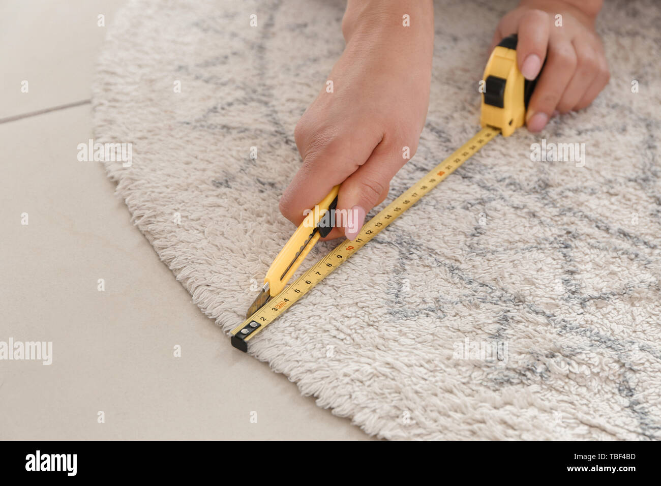 Woman with tape measure cutting carpet Stock Photo Alamy