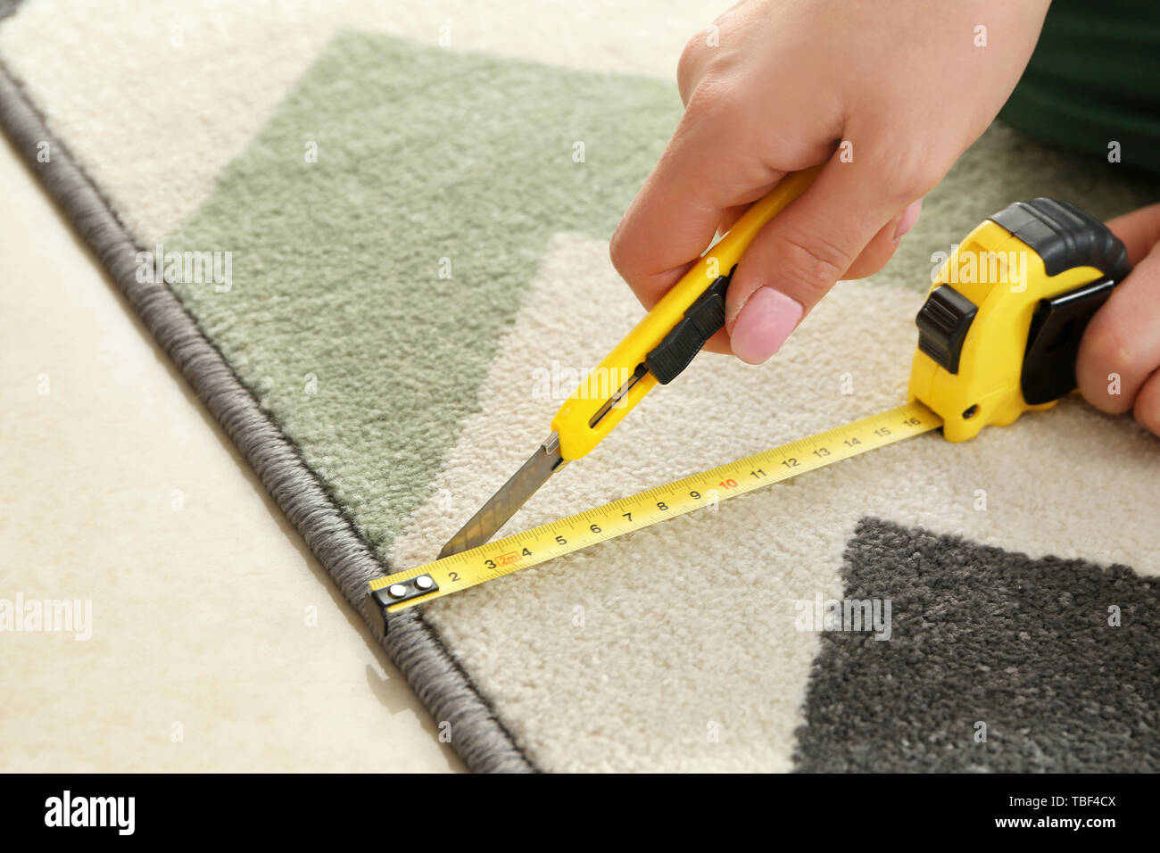 Woman with tape measure cutting carpet Stock Photo Alamy