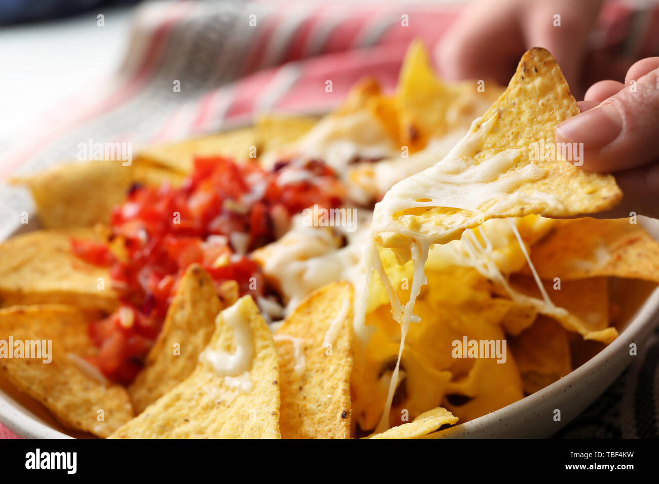 Woman eating tasty nachos with cheese, closeup Stock Photo
