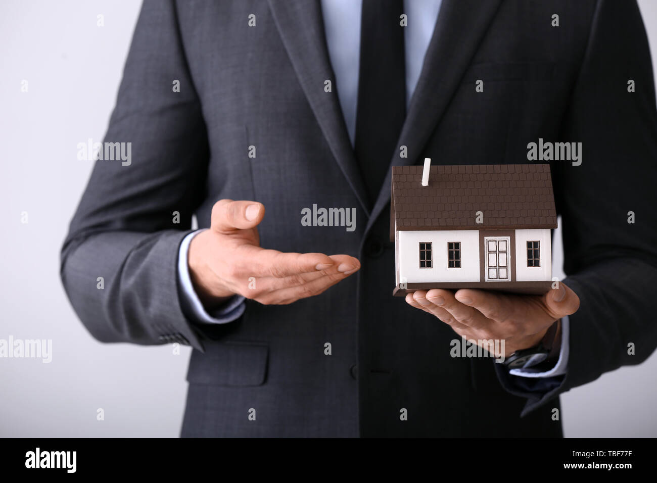 Insurance agent with model of house on 