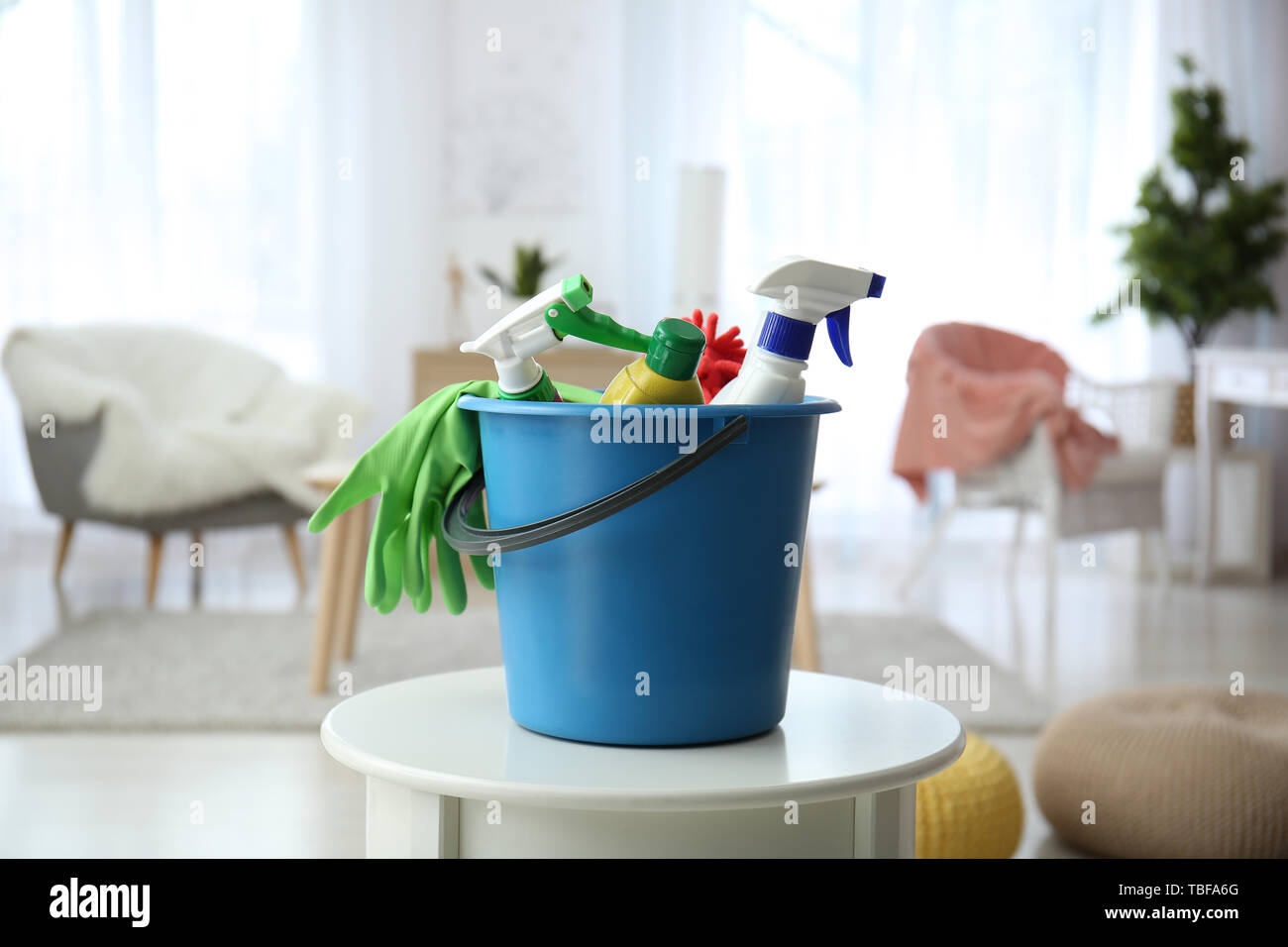 Bucket with cleaning supplies on table at home Stock Photo - Alamy