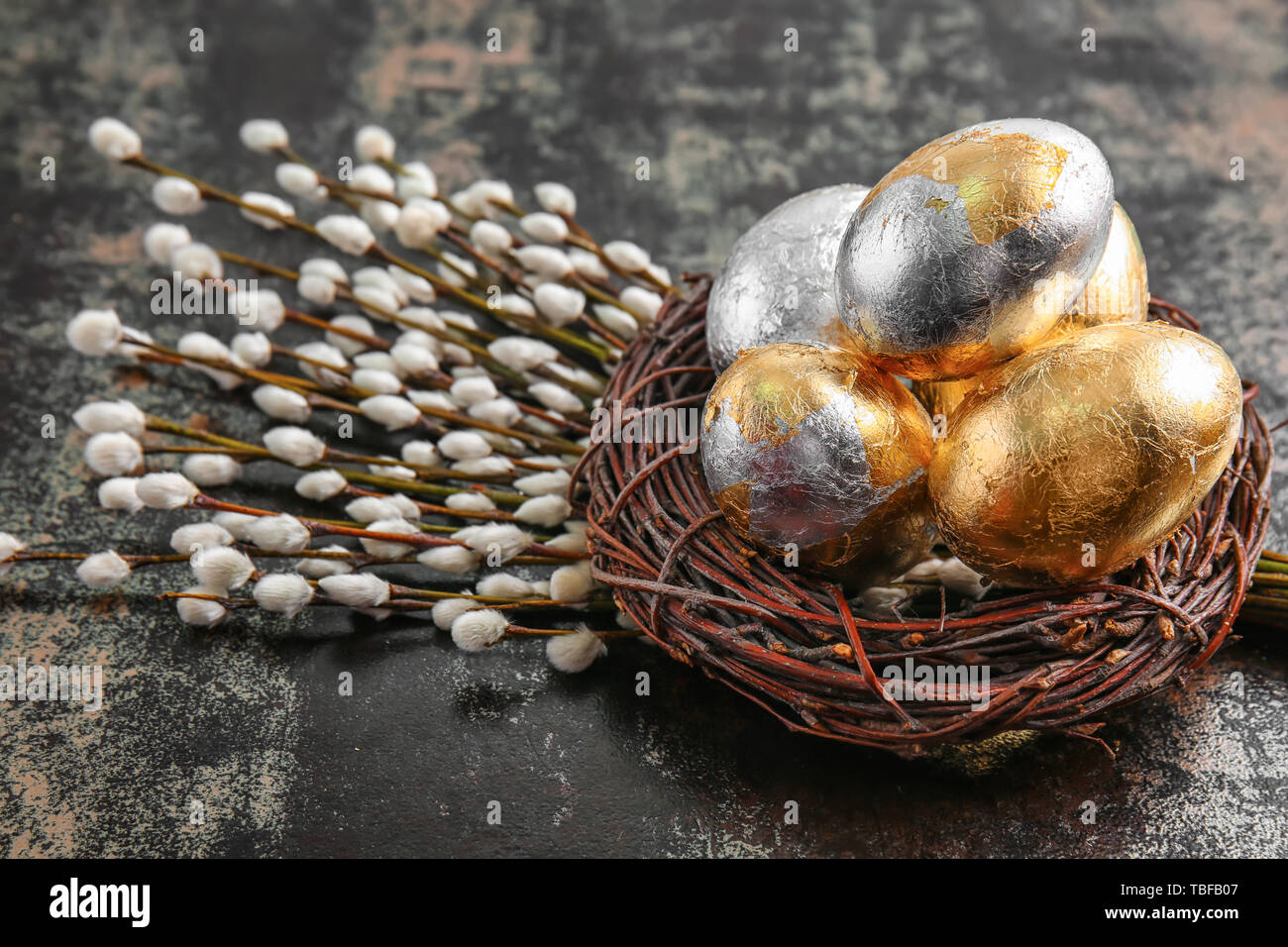 Nest with beautiful Easter eggs and pussy willow branches on dark ...