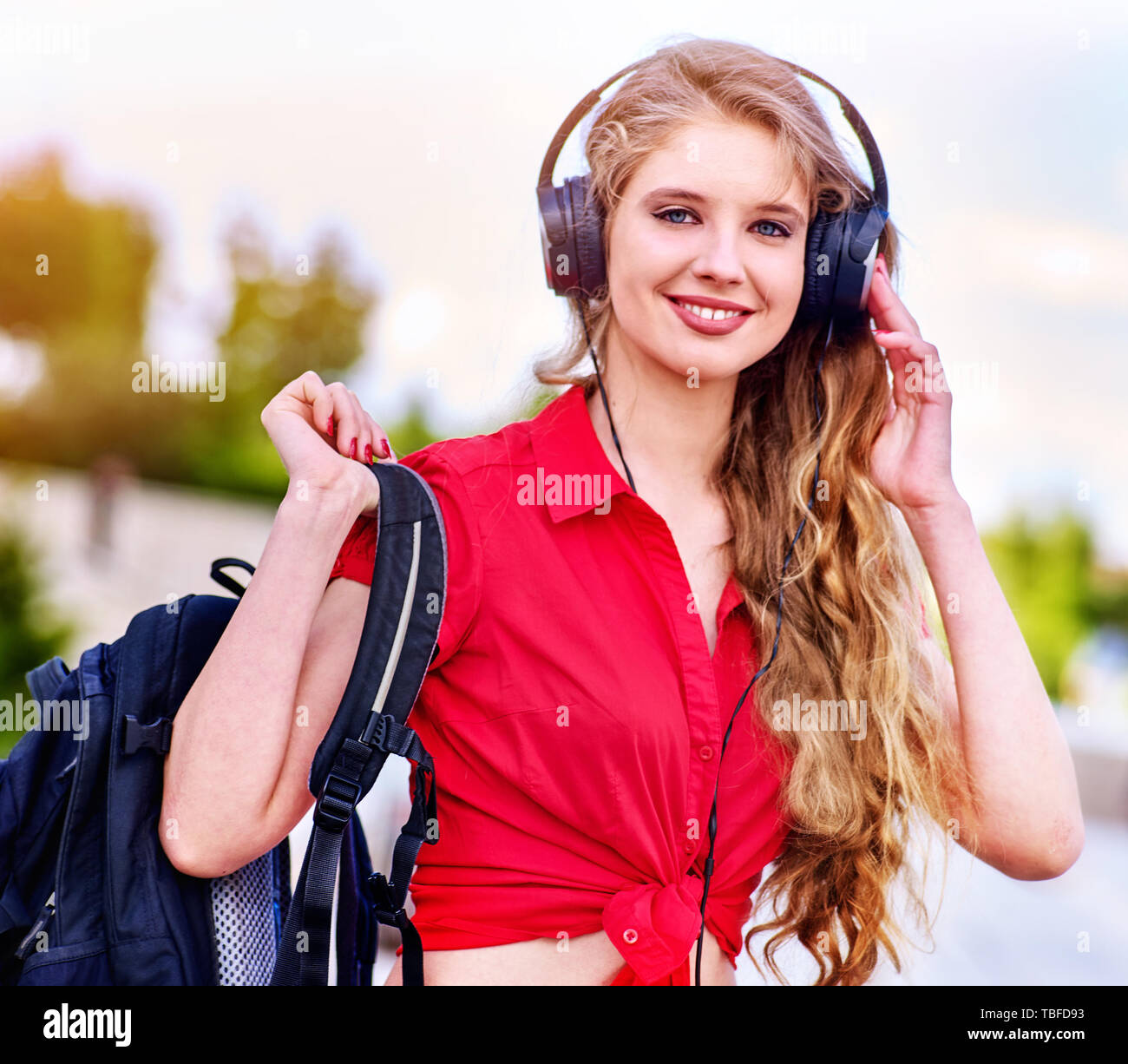 Student girl with backpack in headphone listen music after exam. Time ...