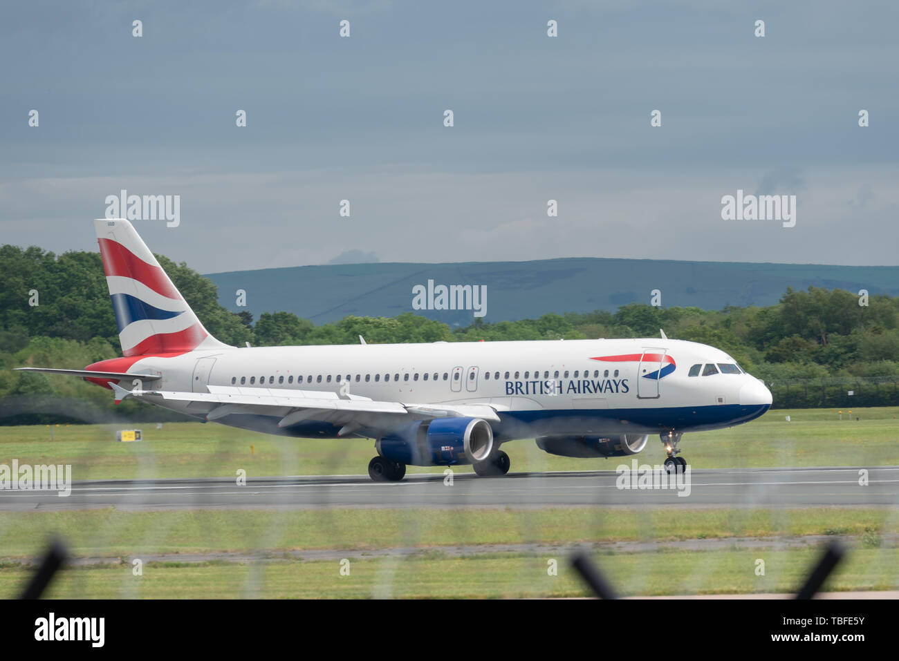 MANCHESTER UK, 30 MAY 2019: British Airways Airbus A320 flight BA1394 from London Heathrow lands on Runway 28R at Manchester Airport. Stock Photo