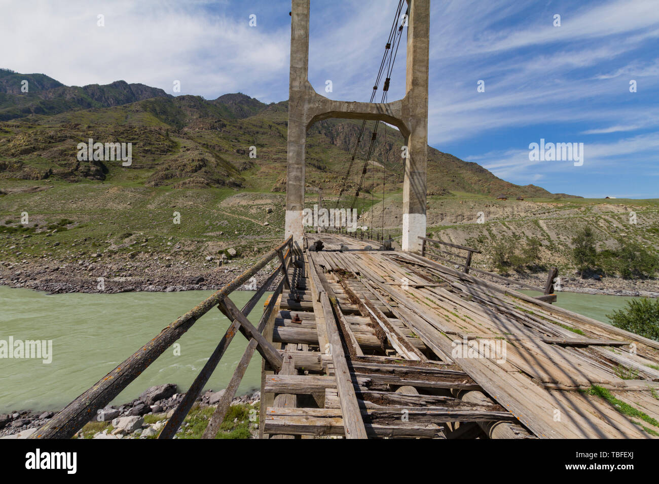 Old wooden Bridge on iron ropes through the Katun River. Summer sunny ...