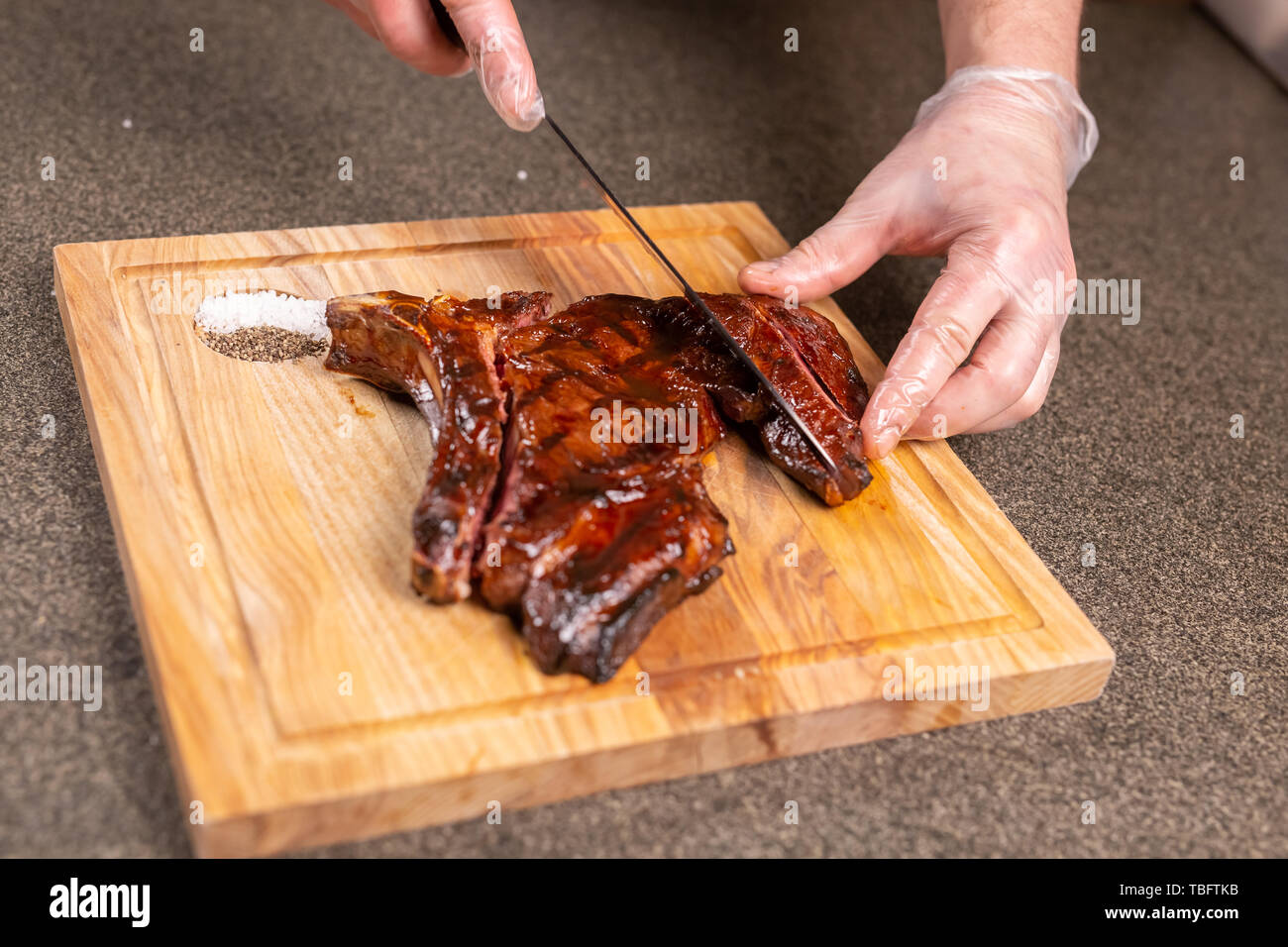 food-delicious-and-craft-concept-man-cutting-horse-meat-steak-stock