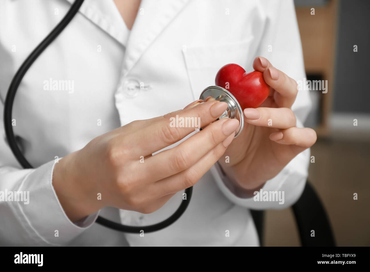 Cardiologist with red heart and stethoscope in clinic, closeup Stock Photo Alamy