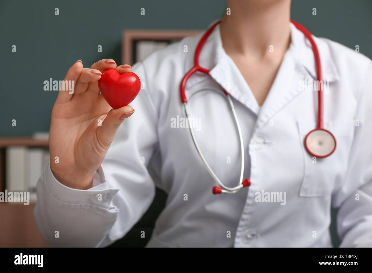 Cardiologist with red heart in clinic Stock Photo - Alamy
