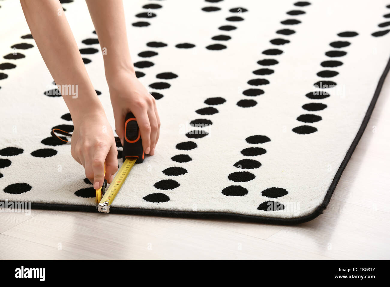 Woman with tape measure cutting carpet on floor Stock Photo Alamy