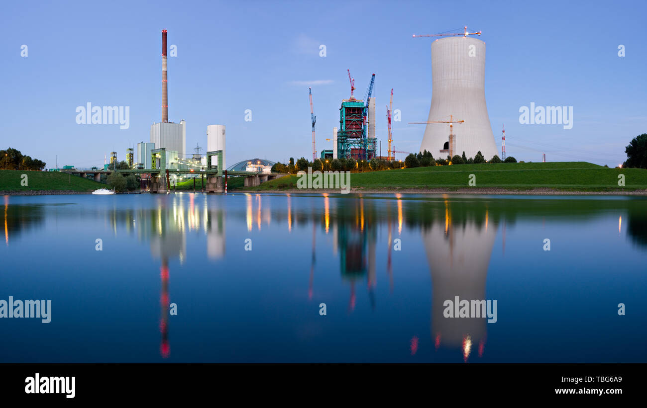 An old and a new power station at dusk with reflection. Industry in Duisburg-Walsum, Germany. Stock Photo