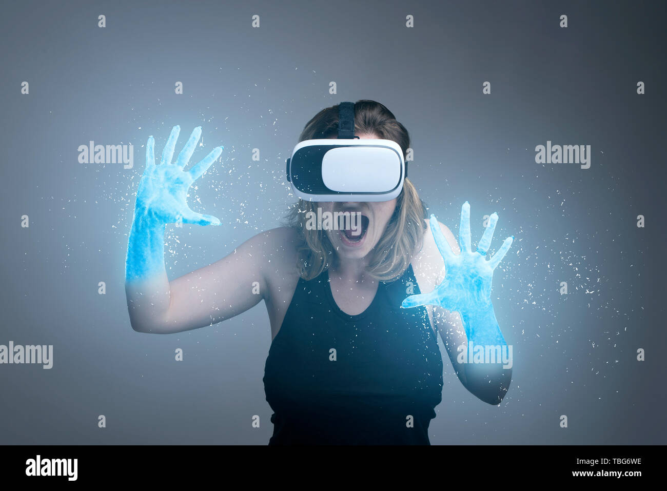Girl using VR gadget with hands turning into ice in a virtual cyber simulator Stock Photo