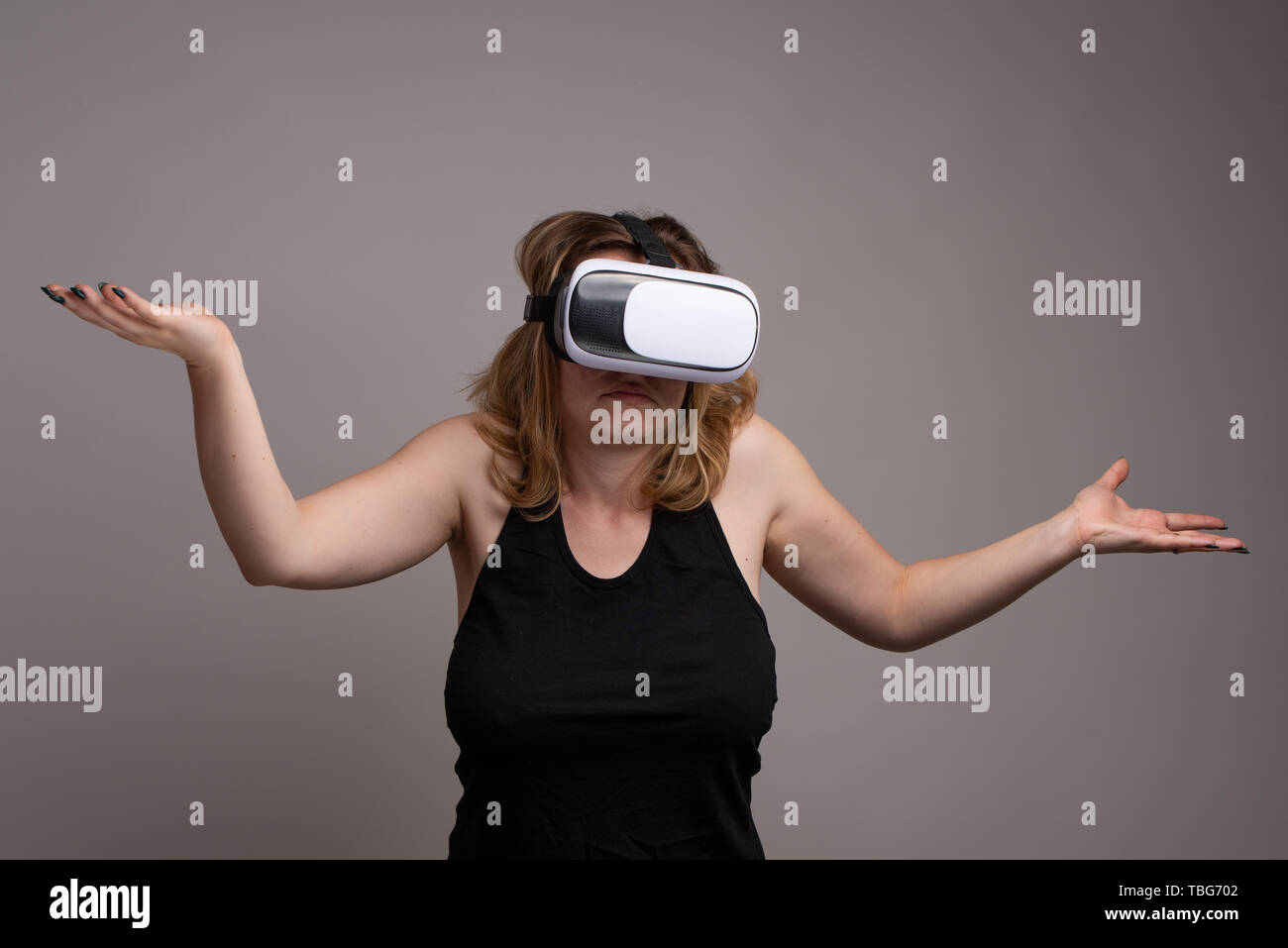 Female using VR gear is displaying a don't know attitude Stock Photo