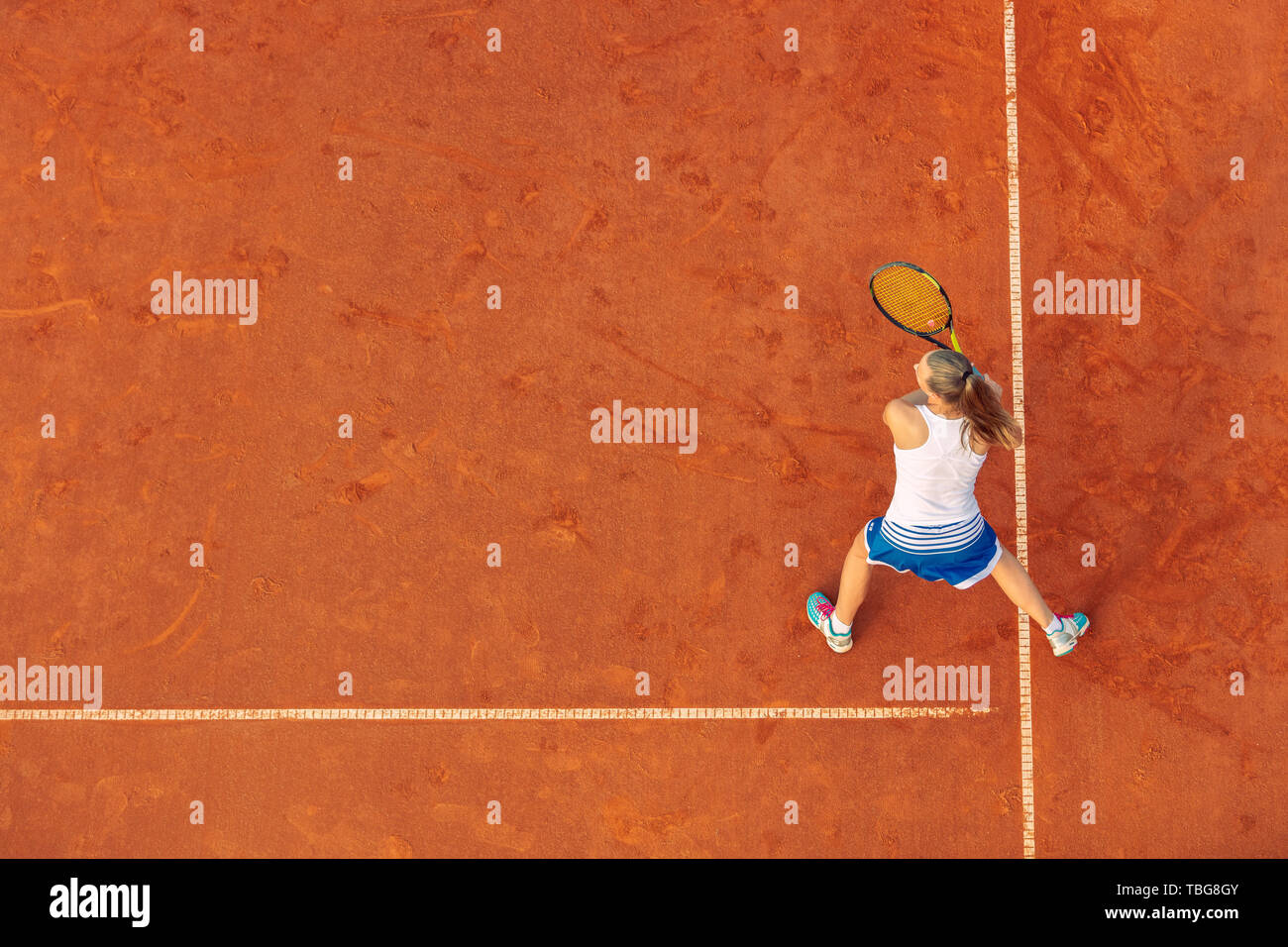 Aerial shot of a female tennis player on a court during match. Young