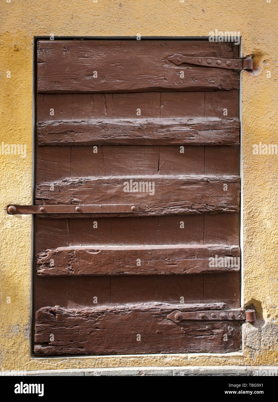 Rustic brown wooden window shutters with stone wall yellow background ...