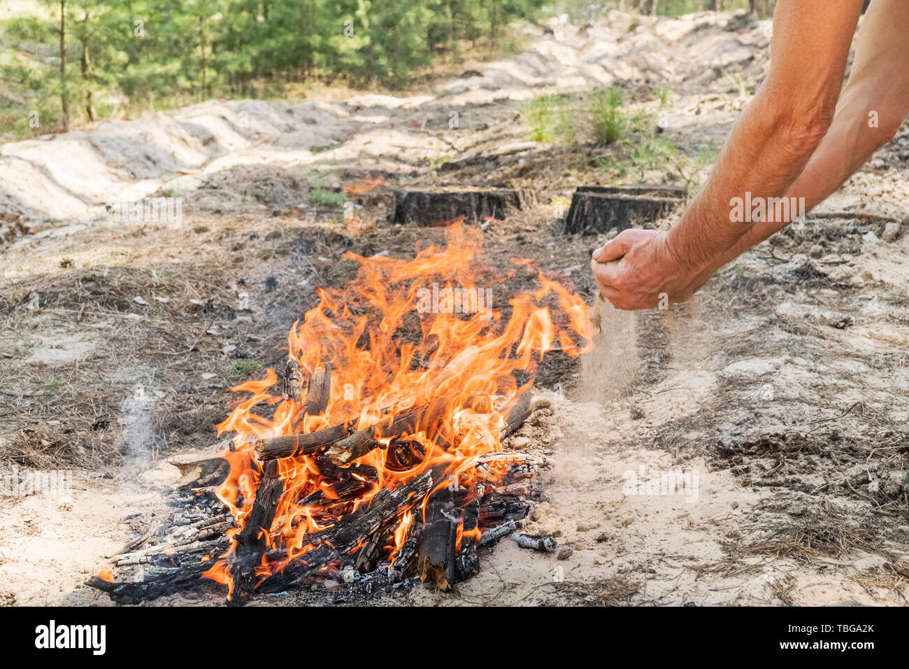 Man Putting Out A Fire With Sand Stock Photo Alamy
