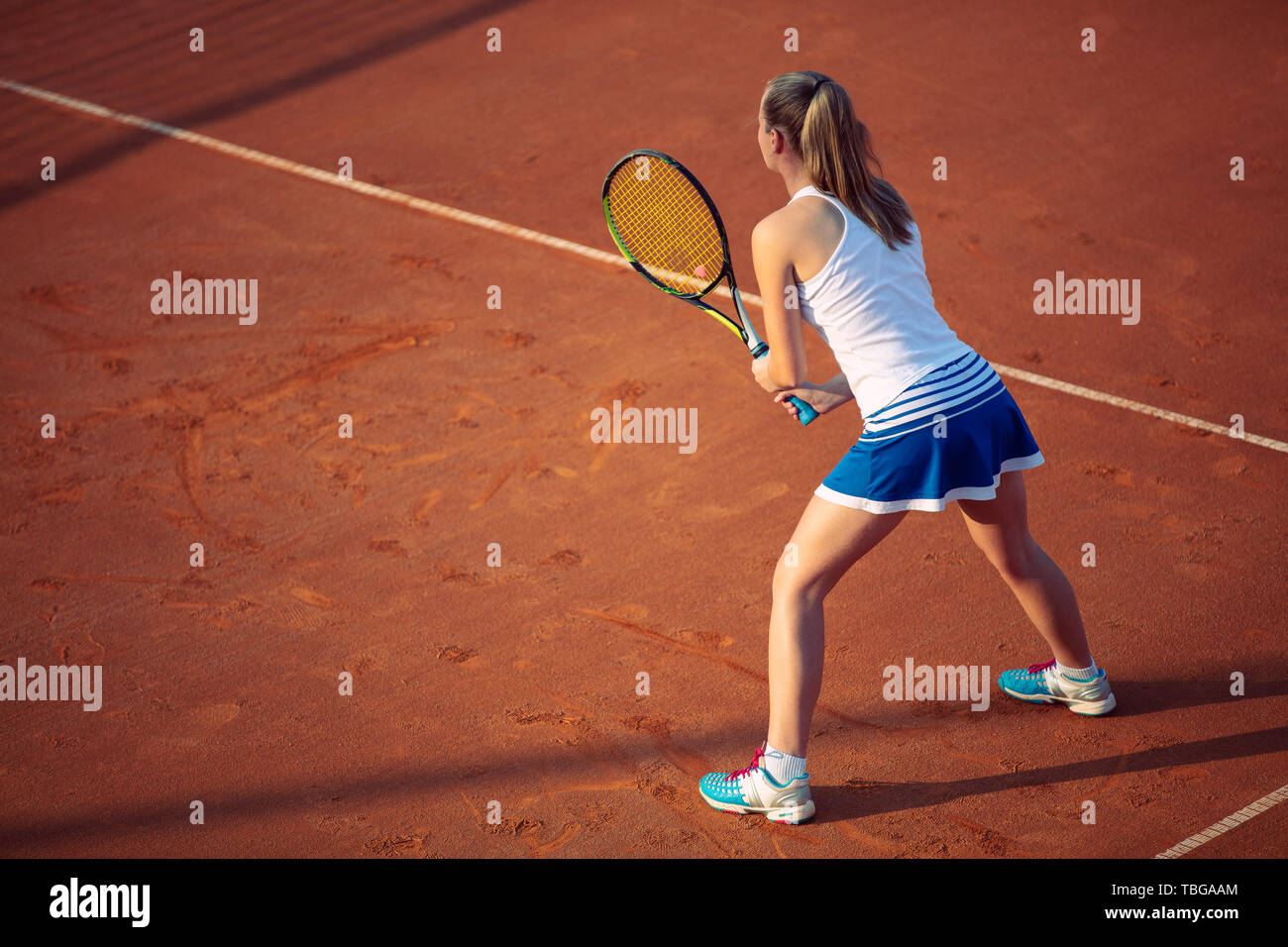 Aerial shot of a female tennis player on a court during match. Young woman playing tennis.High angle view. Stock Photo