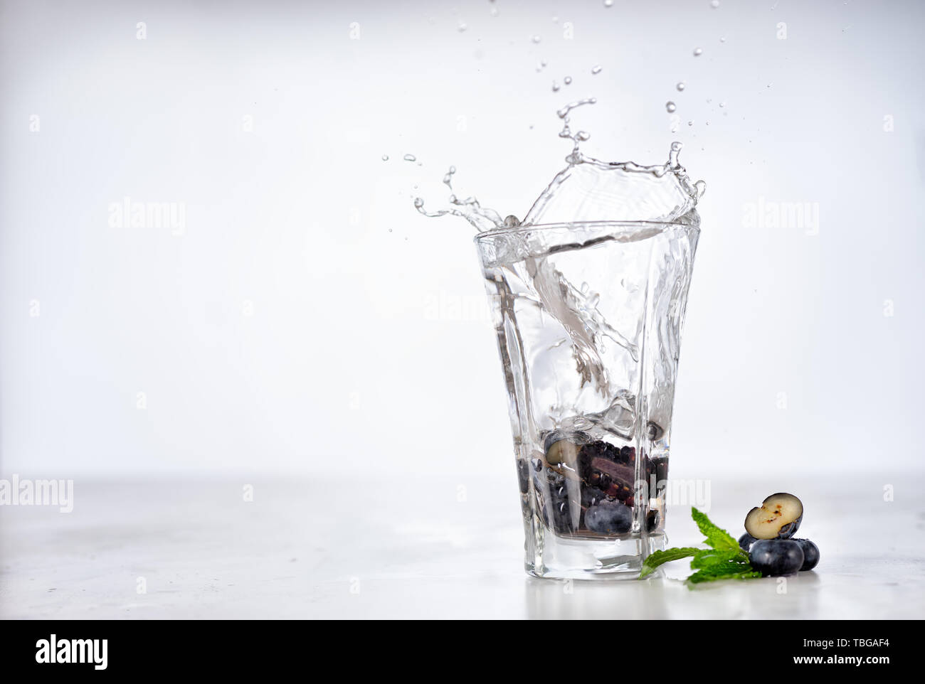 Splash into glass of infused water with berries and mint Stock Photo