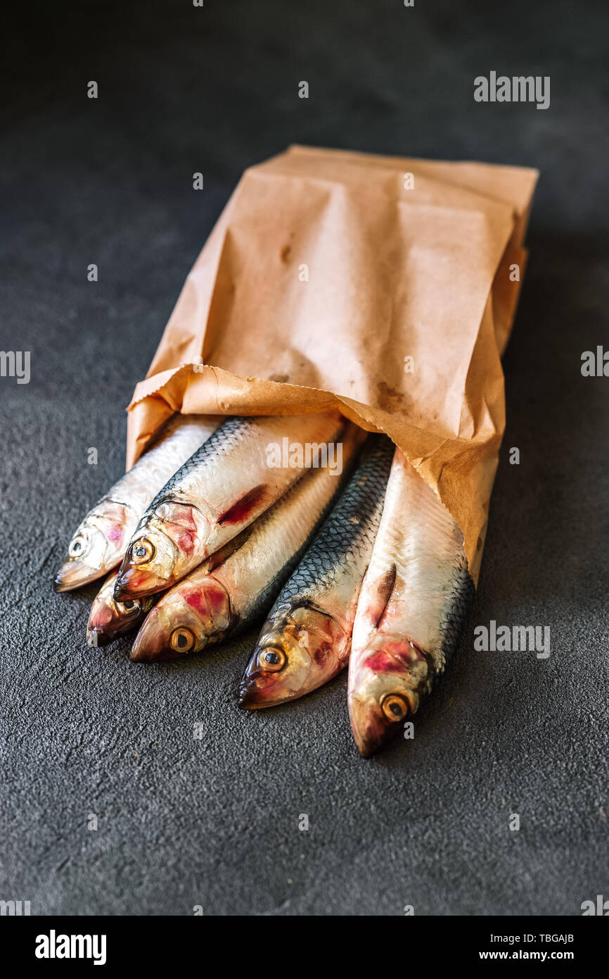 Raw herring in eco paper bag on a dark background Stock Photo