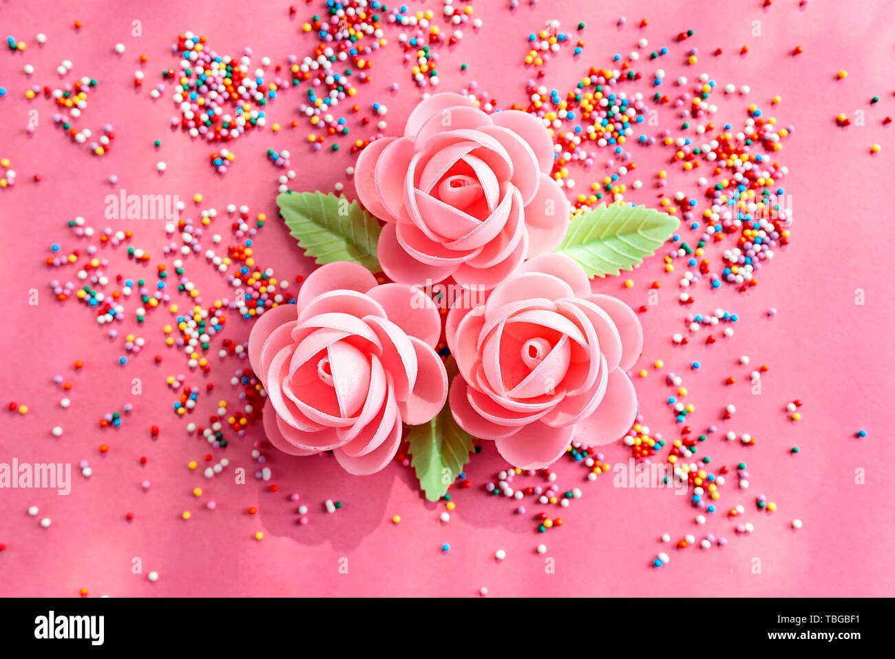 Arrangement of flowers and confetti to decorate sweet pastries. Top viewe, flat lay Stock Photo