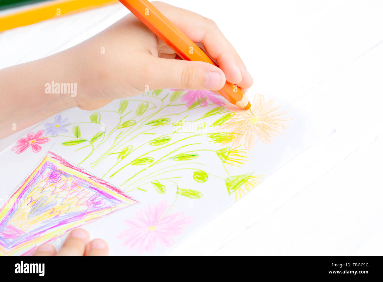 The child draws flowers for mom with pencils. Baby gift. Stock Photo