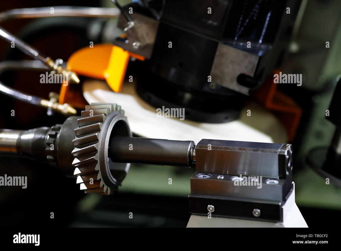CNC gear form grinding machine. Grinding a gear wheel. Selective focus. Stock Photo