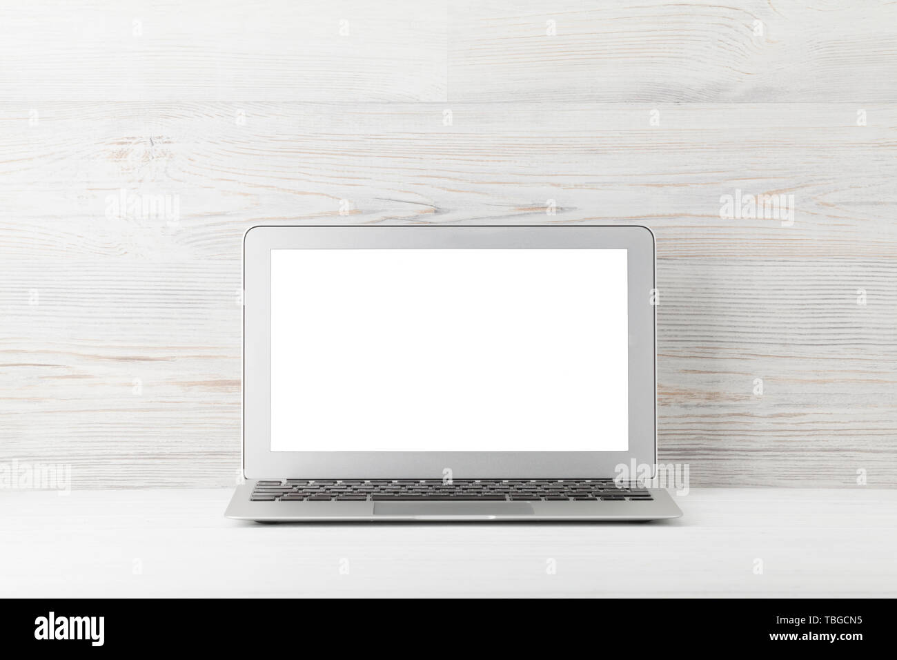 Home office workplace with blank white screen laptop computer. With ...