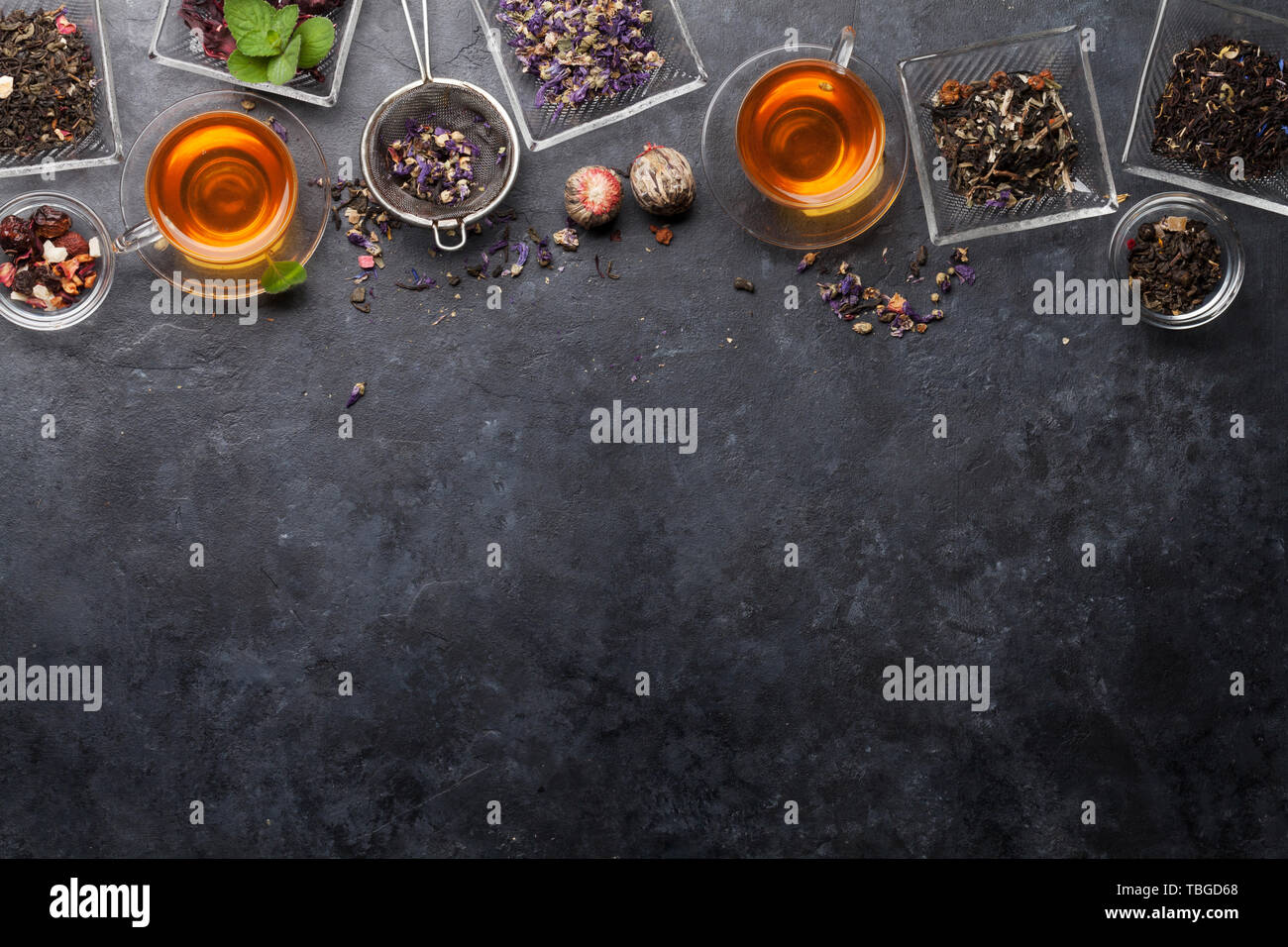 Dry Tea Set of different herbal and fruit dry teas in bowls on stone table. Top ...