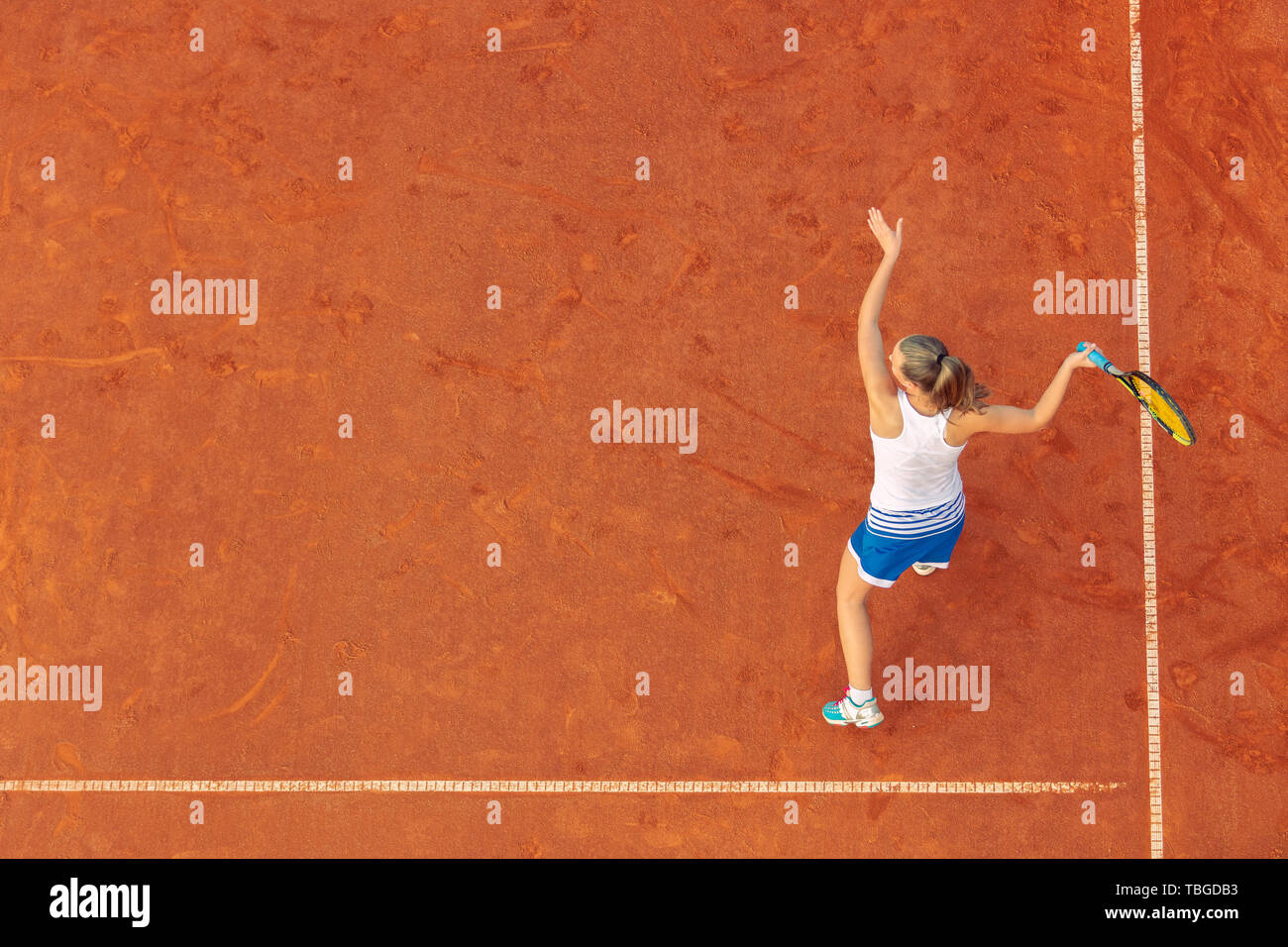 Aerial shot of a female tennis player on a court during match. Young woman playing tennis.High angle view. Stock Photo