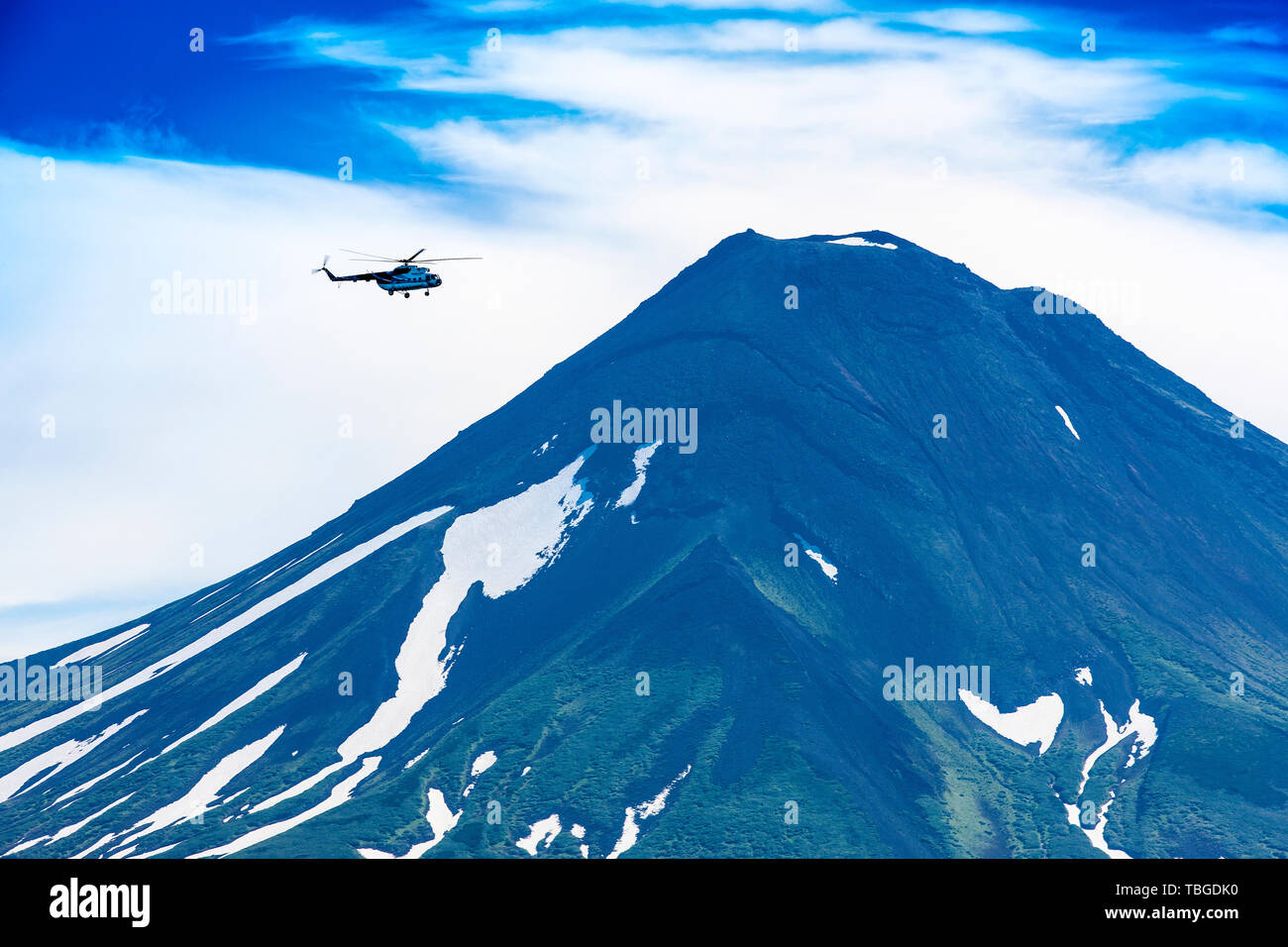 Helicopter flying over Ilyinsky Volcano and Kurile lake Stock Photo