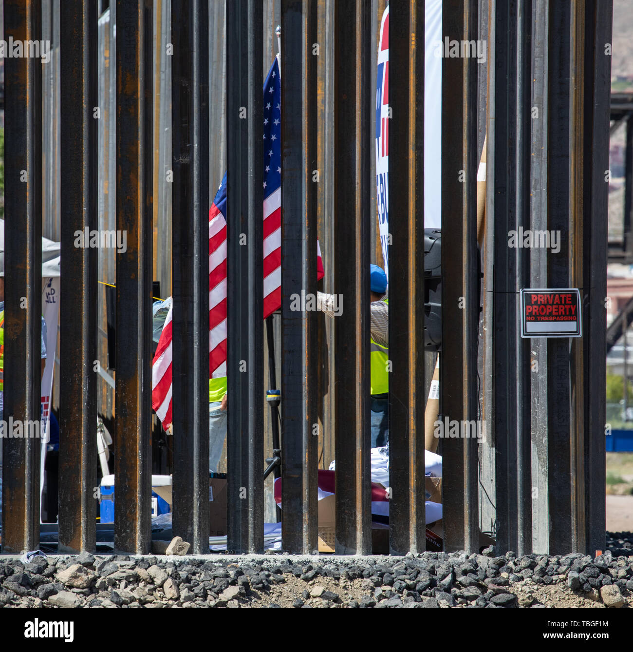 An American Flag is seen behind the metal bars of the border fence next to a No Trespassing Sign, We Build the Wall rally, Sunland Park, New Mexico, 3 Stock Photo