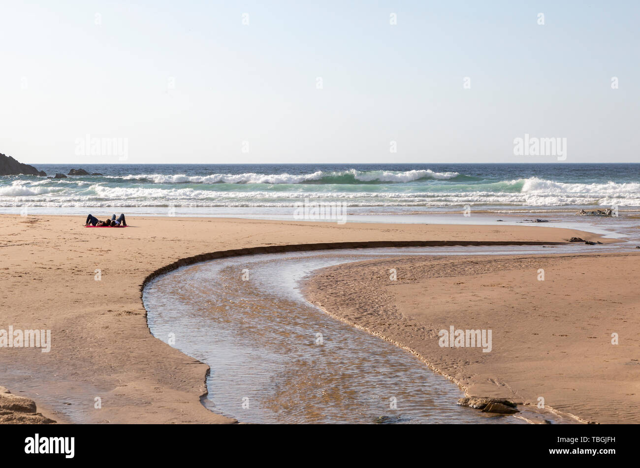 Two people lying by sea on sandy Praia Carvalhal beach, Brejão, Alentejo Littoral, Portugal, Southern Europe Stock Photo