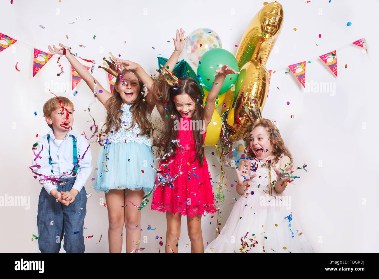 Group of beautiful kids throwing colorful confetti and looking happy on ...