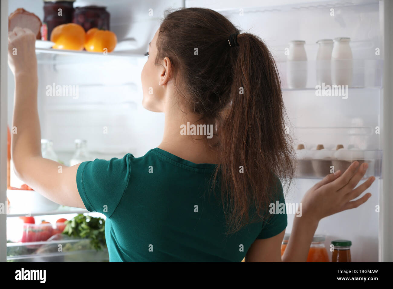 Woman taking food out of fridge at home Stock Photo Alamy