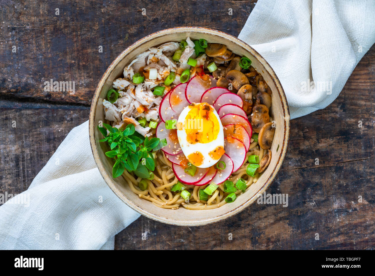 Ramen noodles with chicken, egg, mushrooms and radish sprinkeld with