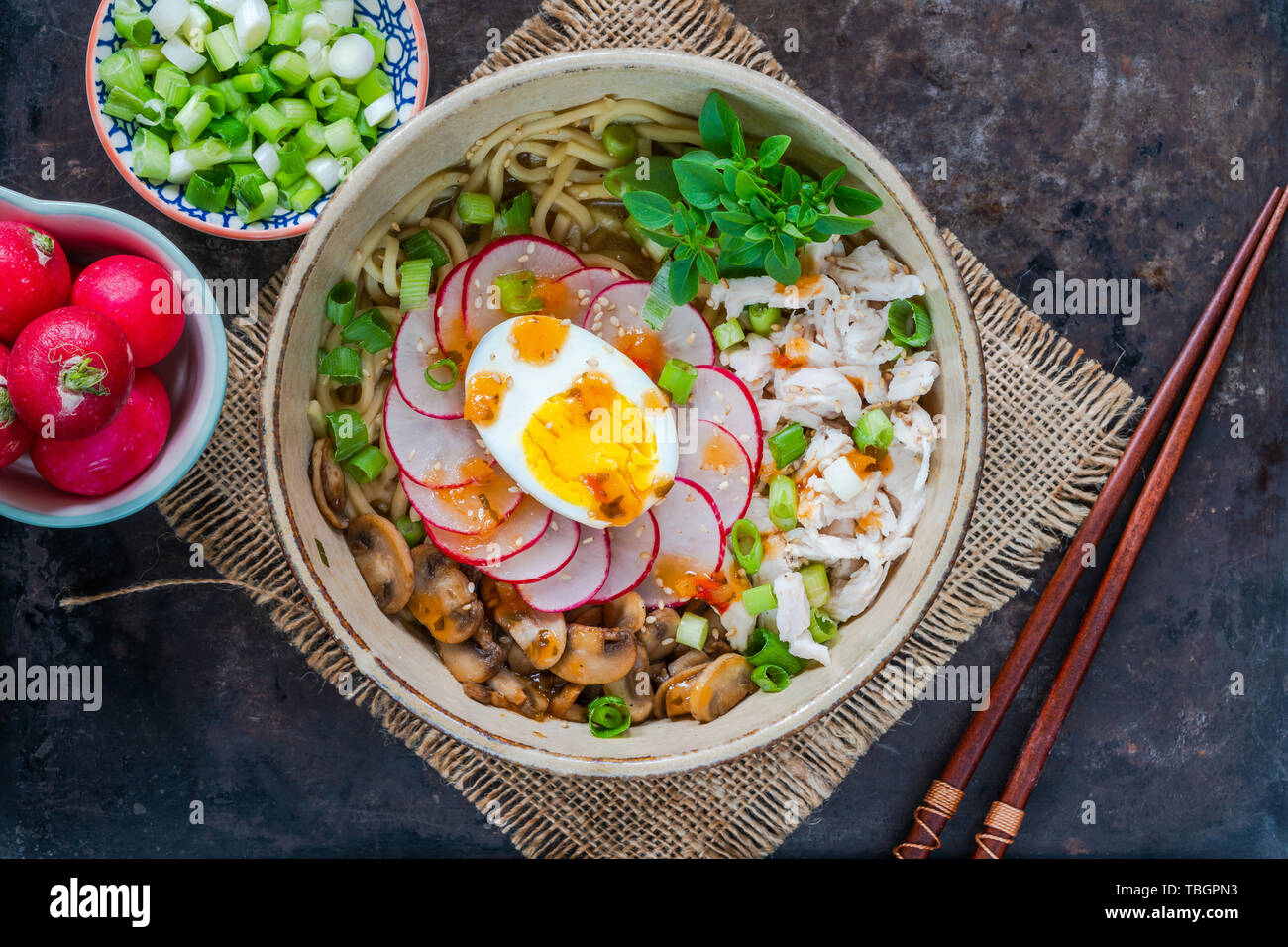 Ramen noodles with chicken, egg, mushrooms and radish sprinkeld with