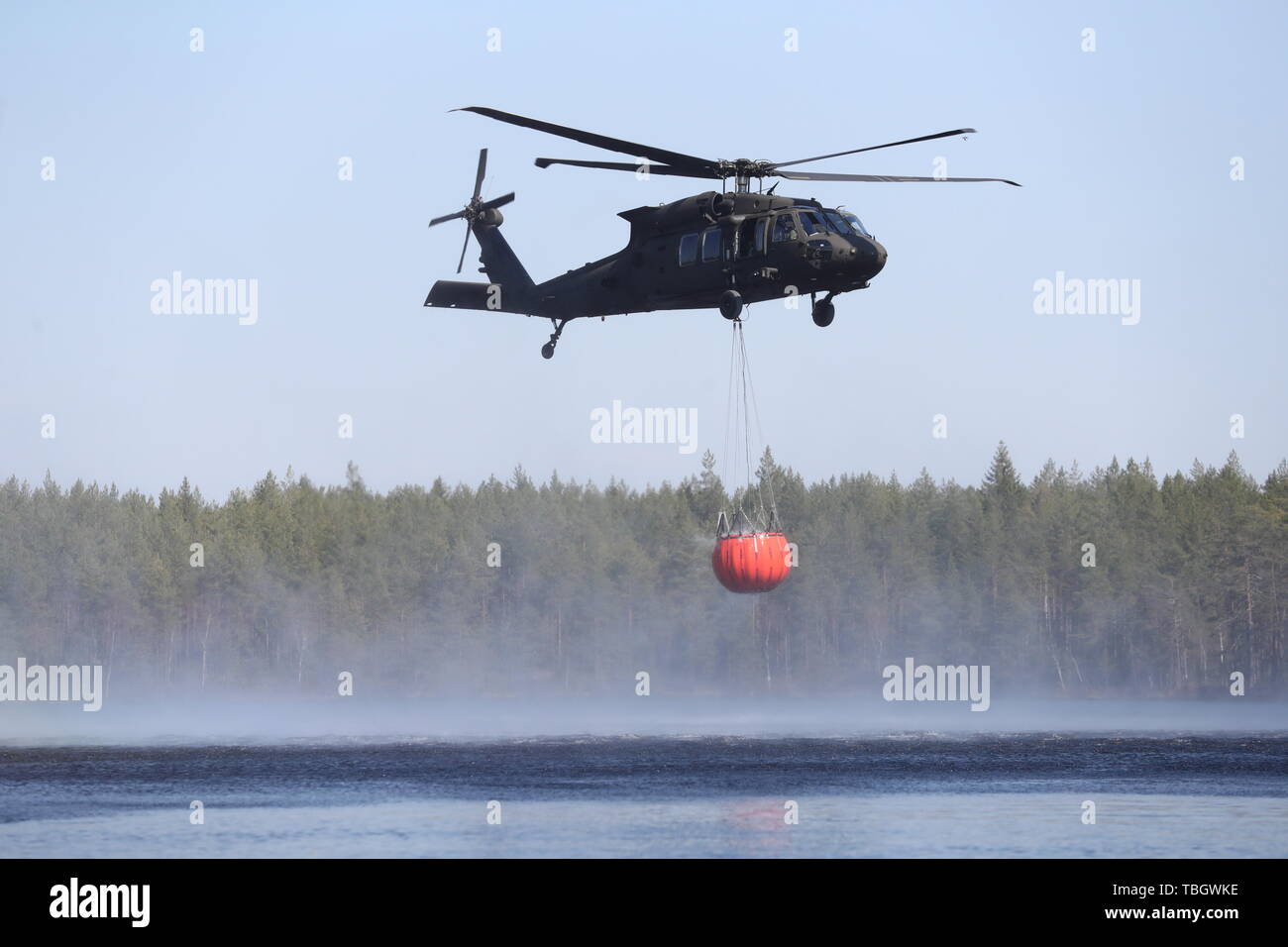 Helicopter water bombs over the forest fire just north of Tjällmo Stock