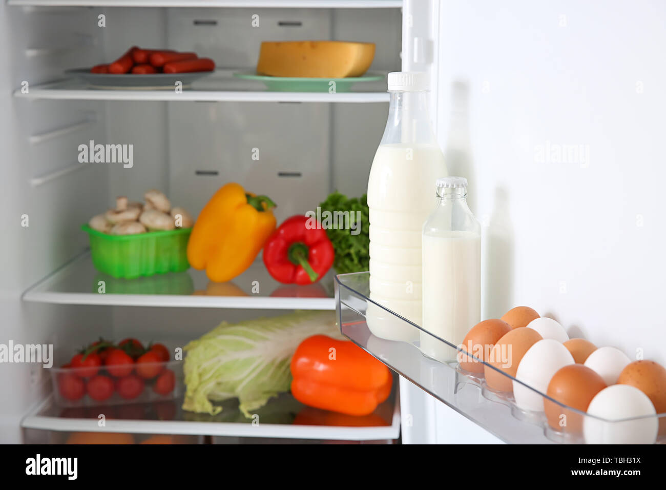 Eggs and milk in open fridge Stock Photo Alamy