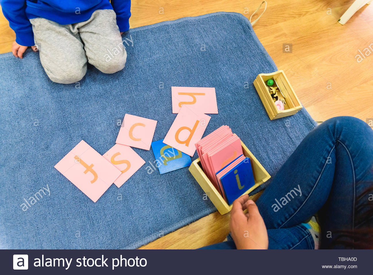 Students Handling Montessori Material In A School On A Mat During