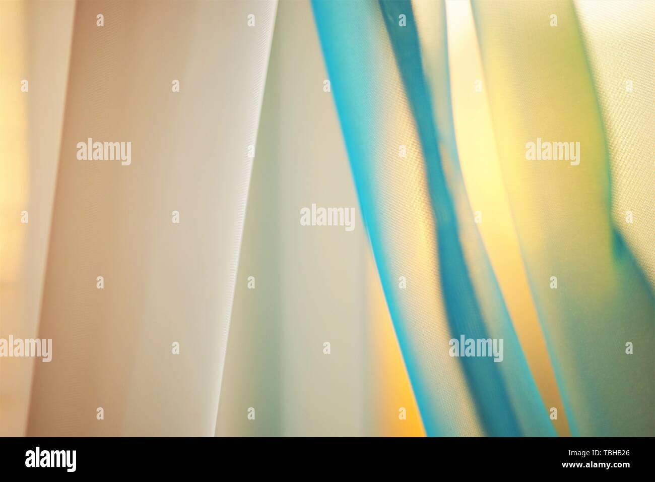 Sunny sunset light through the thin curtains on the window Stock Photo