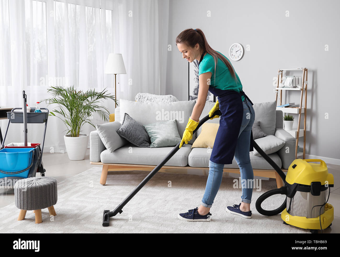 Female janitor with vacuum cleaner in room Stock Photo Alamy