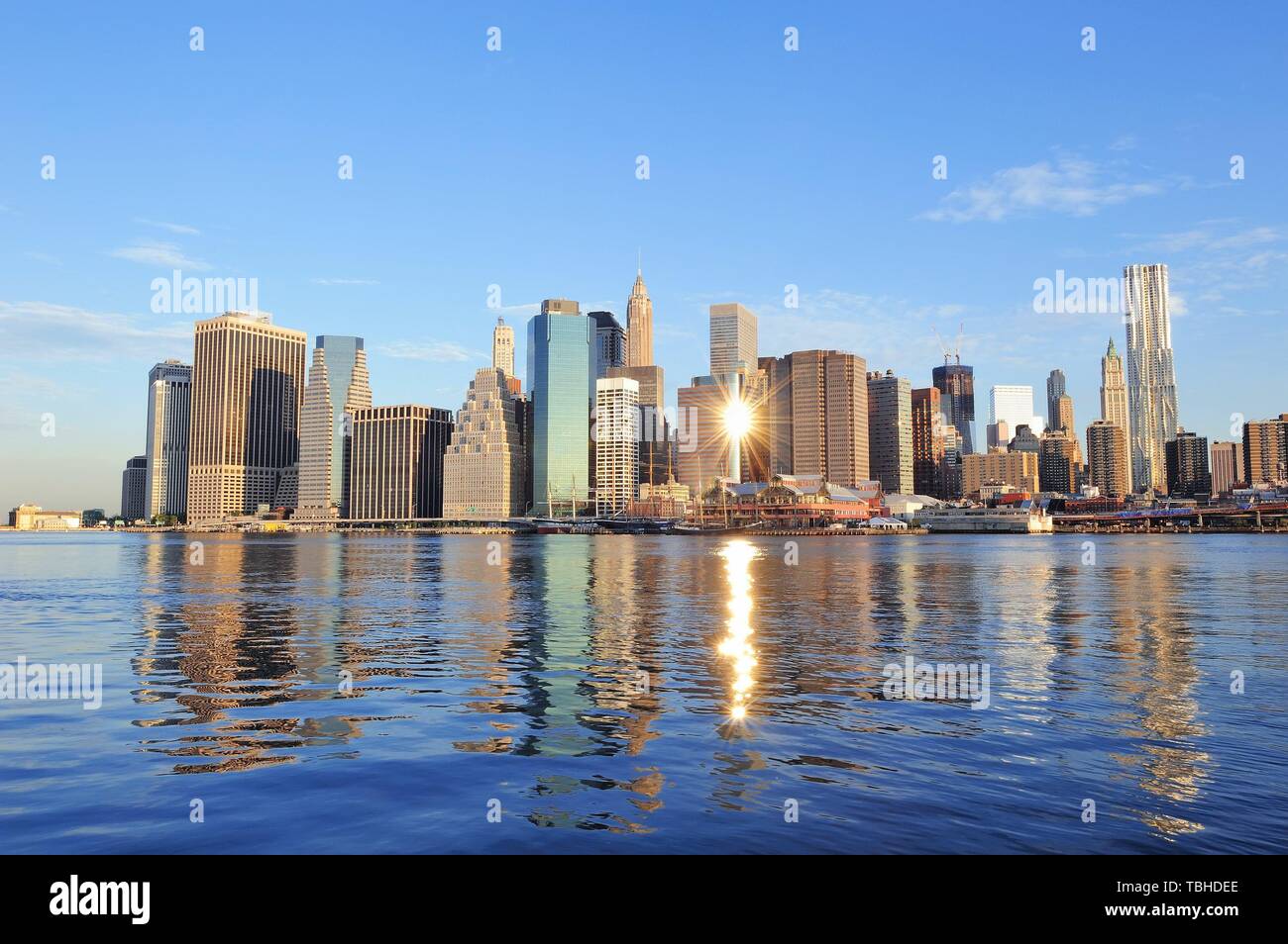 Lower Manhattan skyline panorama over East River with reflection and ...
