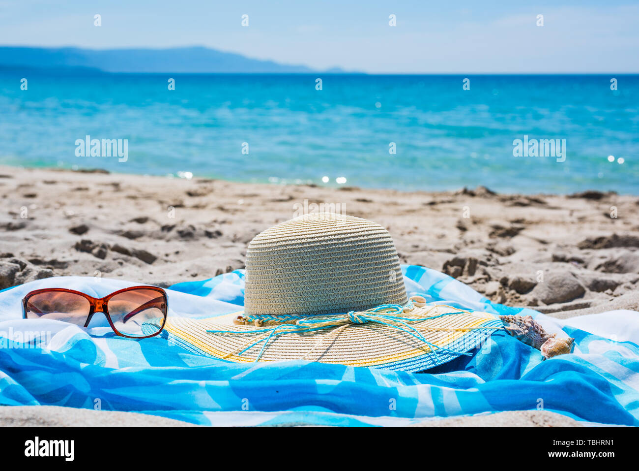 straw hat and sunglasses on the sand Stock Photo - Alamy