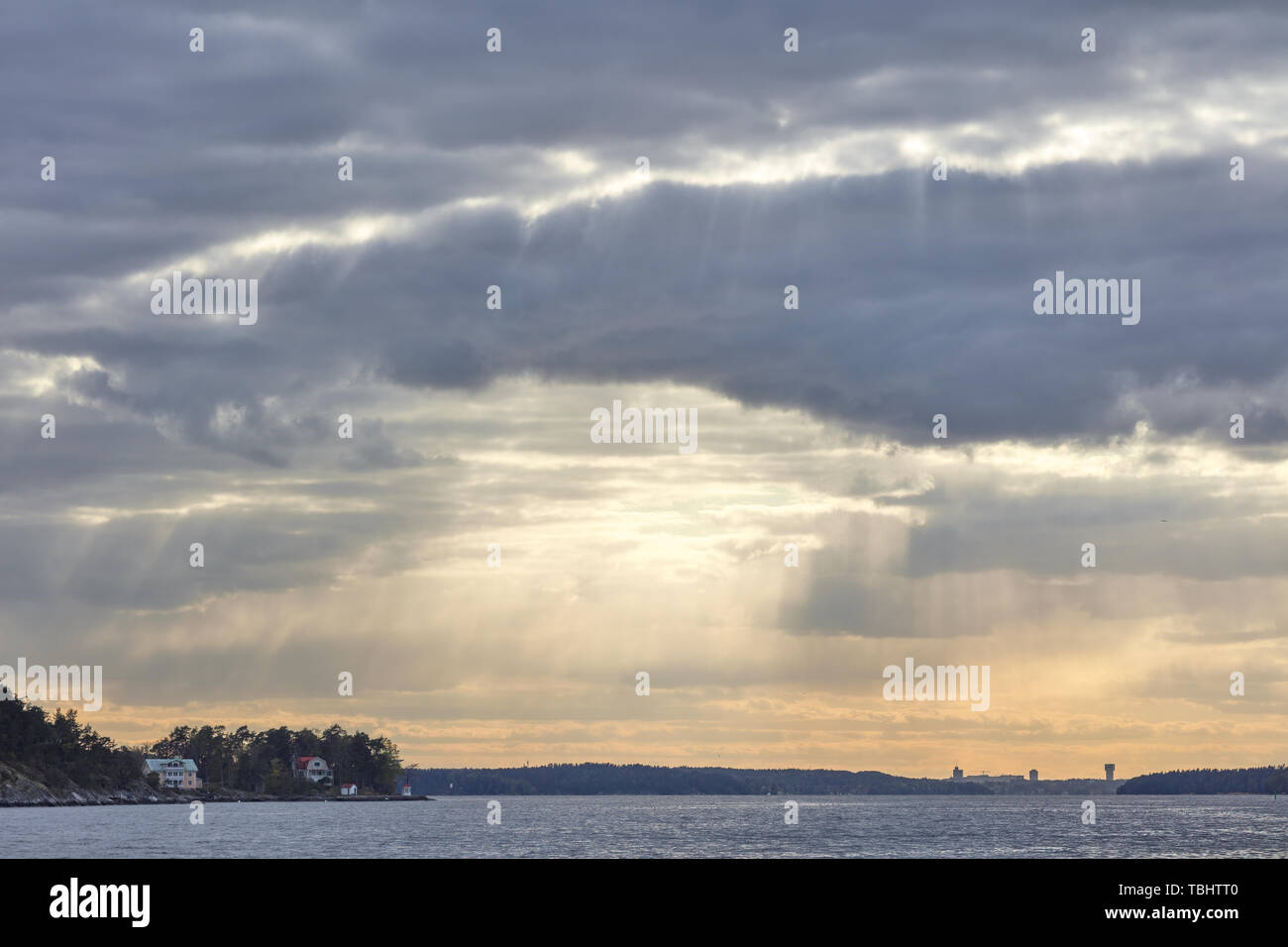 Sunrays through dramatic clouds above Västra Granholmen, near Vaxholm, Sweden Stock Photo