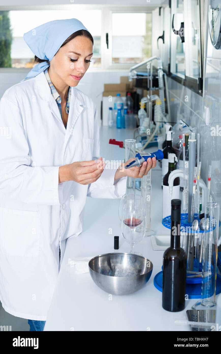 young woman expert checking wine acidity and sugar saturation in
