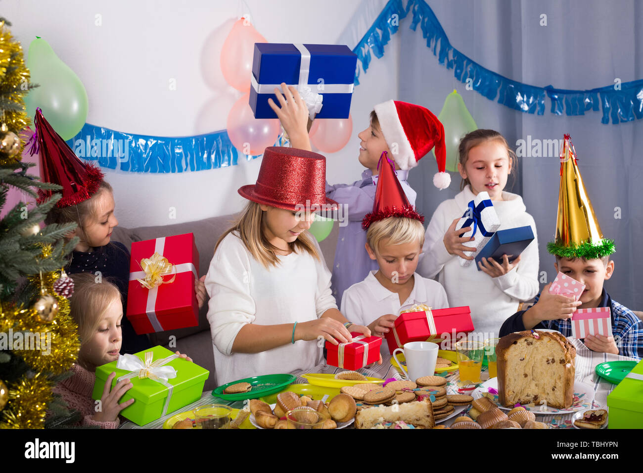 happy children presenting gifts during Christmas dinner Stock Photo - Alamy